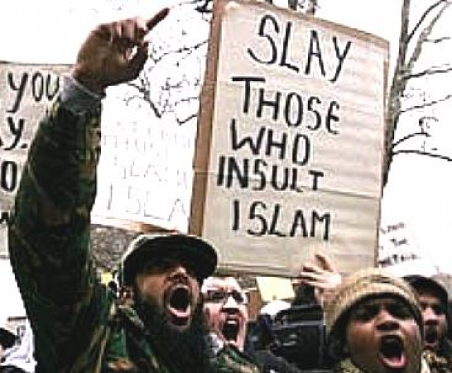 A photo of a protest by Muslims, in which a sign being held up reads: "Slay those who insult Islam."